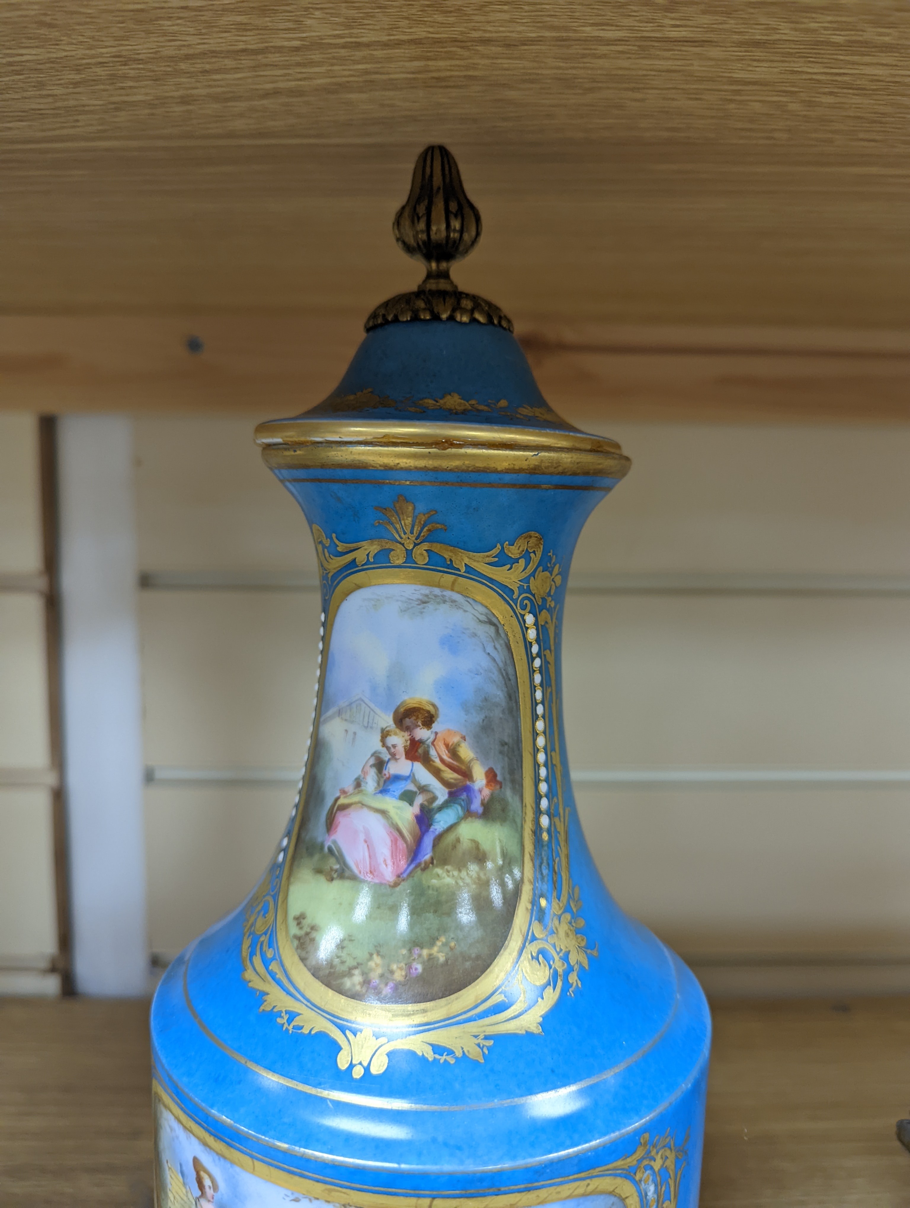 A pair of Sevres style porcelain bleu celeste ground vases and covers, 34cm